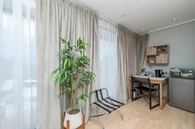 a living room with a table and a plant at The Model House in Cape Town