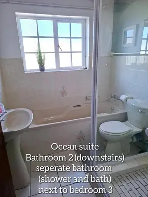 a bathroom with a tub and a toilet and a sink at Mond Kleine Guest House in Kleinmond