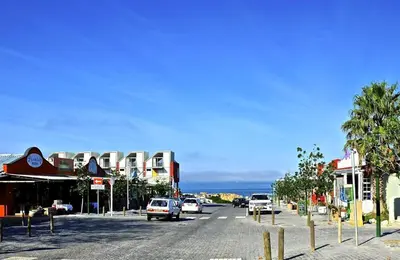 a street in a town with cars parked on the road at Mond Kleine Guest House in Kleinmond