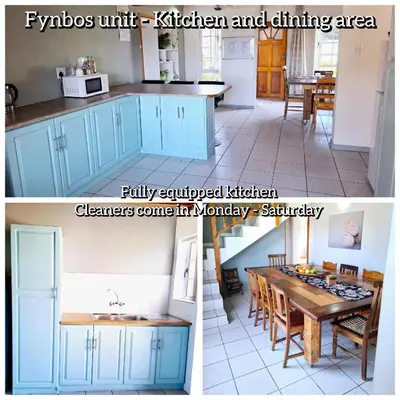 a kitchen and dining room with blue cabinets and a table at Mond Kleine Guest House in Kleinmond