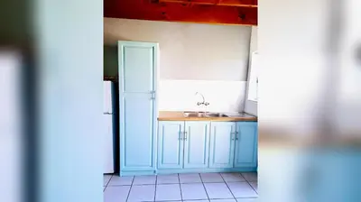 a kitchen with blue cabinets and a sink at Mond Kleine Guest House in Kleinmond