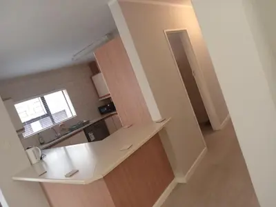 a kitchen with a white counter and a sink at Jackie’s 3 bedroomed secure beach front apartment Strand Golden Mile in Strand