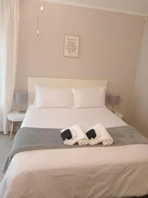 a bedroom with a bed with two towels on it at Jackie’s 3 bedroomed secure beach front apartment Strand Golden Mile in Strand