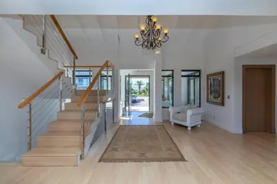 a living room with a staircase and a chandelier at Villa Paradis - ocean front with views to behold! in Cape Town
