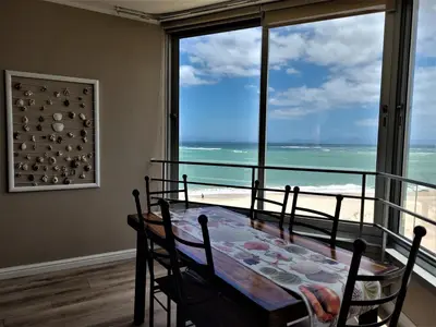 a dining room with a table and a view of the ocean at On The Beach At Strand in Strand
