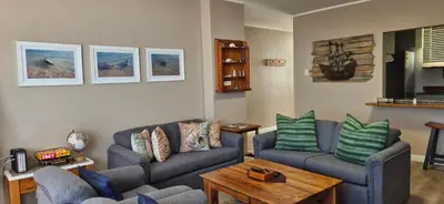 a living room with two couches and a table at On The Beach At Strand in Strand