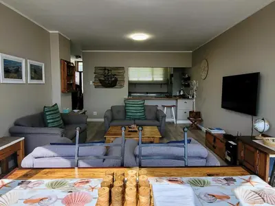 a living room with two couches and a tv at On The Beach At Strand in Strand