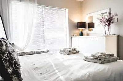 a bedroom with a bed with towels on it at Seagull Hermanus in Hermanus
