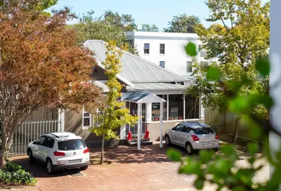 two cars parked in front of a house at Hotel Krige in Stellenbosch