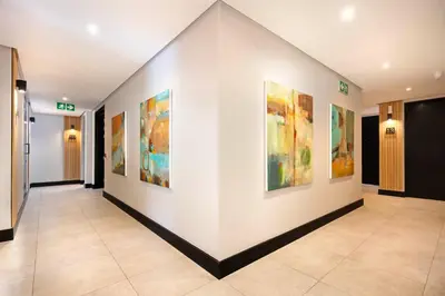 a hallway with paintings on the walls of a building at Hotel Krige in Stellenbosch
