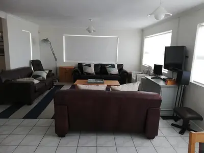 a living room with a couch and a tv at Ocean View in Hermanus