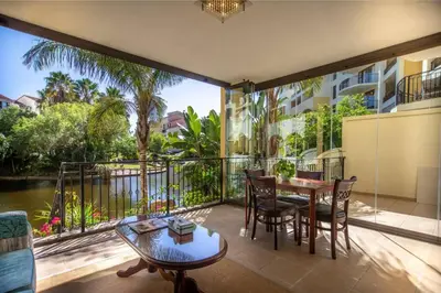a room with a balcony with a table and chairs at Portifino On Lake G16 The Island Club in Cape Town