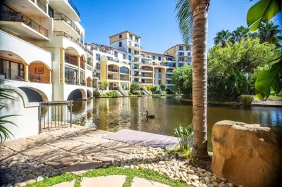 a hotel with a pond in front of a building at Portifino On Lake G16 The Island Club in Cape Town