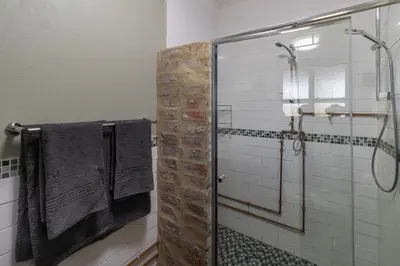 a bathroom with a glass shower stall with towels at Steenbok farm cottages -Mongoose cottage in Wolseley