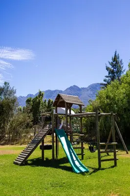 a playground with a slide in a park at Steenbok farm cottages -Mongoose cottage in Wolseley