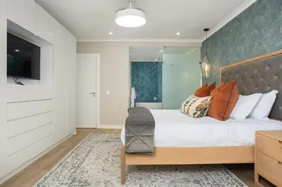 a bedroom with a large bed and a television at Dolphin Beach E30 in Cape Town