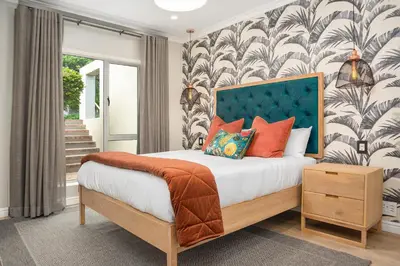 a bedroom with a bed with a blue headboard at Dolphin Beach E30 in Cape Town