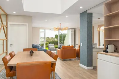 a kitchen and living room with a table and chairs at Dolphin Beach E30 in Cape Town
