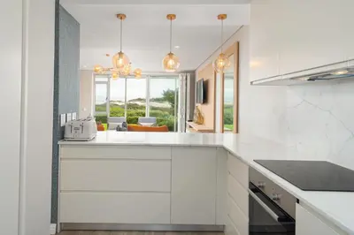a kitchen with white counters and a large window at Dolphin Beach E30 in Cape Town