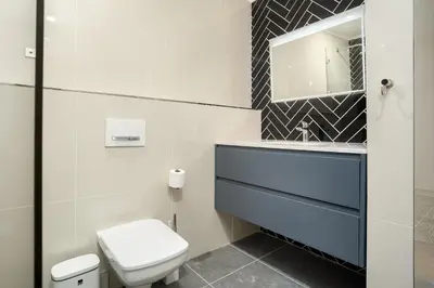 a bathroom with a toilet and a sink and a mirror at Dolphin Beach E30 in Cape Town