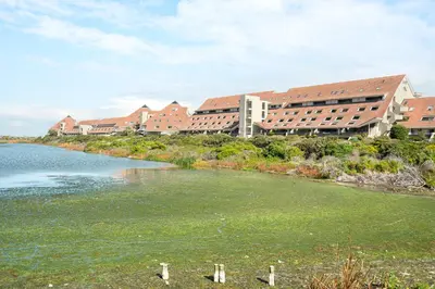 a large building next to a body of water at Dolphin Beach E30 in Cape Town