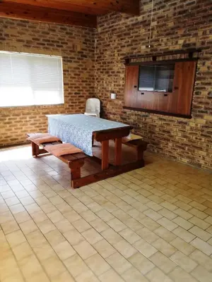 a room with a table and a bench in a brick wall at C the C - Holiday Home in Hermanus