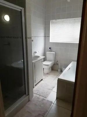 a bathroom with a shower and a toilet and a sink at C the C - Holiday Home in Hermanus