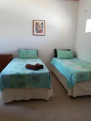 two twin beds in a room with blue sheets at C the C - Holiday Home in Hermanus