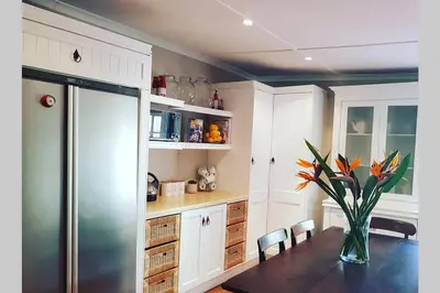 a kitchen with a table with a vase of flowers at Hoogwater Farmhouse in Wolseley