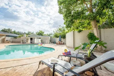 a swimming pool with two chairs and a table next to at Hoogwater Farmhouse in Wolseley
