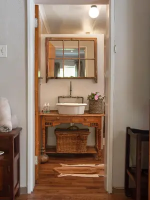 a bathroom with a sink and a mirror at Hoogwater Farmhouse in Wolseley