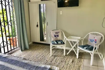 a room with two chairs and a table and a window at The West Wing guest suite. Pringle Bay. in Pringle Bay