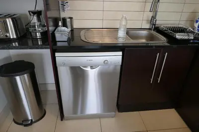 a kitchen counter with a sink and a dishwasher at Little Venice Self Catering in Bellville