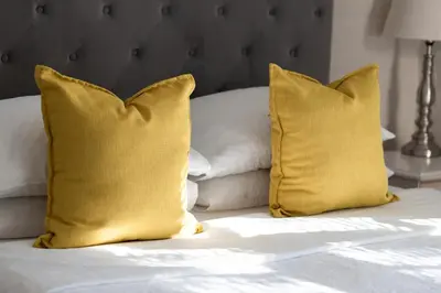 two yellow pillows sitting on a white bed at 17Peppertree in Cape Town