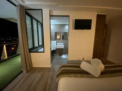 a hotel room with a view of a bathroom at On the GBay Villa in Gordonʼs Bay