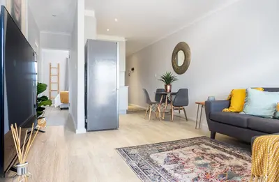 a living room with a couch and a table at 6 Atlantic Port - Cosy, modern 2-bedroom apartment - Blouberg in Bloubergstrand