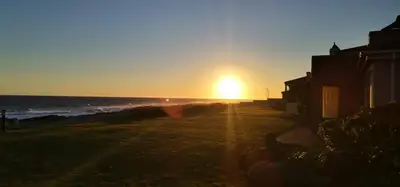 a sunset on a beach with the ocean at Hermanus Beach Club - Le Maree House 18 in Hermanus