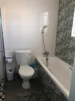 a bathroom with a toilet and a bath tub at Hermanus Beach Club - Le Maree House 18 in Hermanus