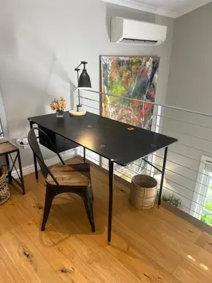 a black table with a chair in a room at Magnolia Cottage in Cape Town