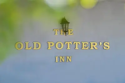 a sign that says the old potters inn at Old Potters Inn in Greyton