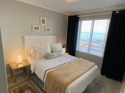 a bedroom with a white bed and a window at CView in Hermanus