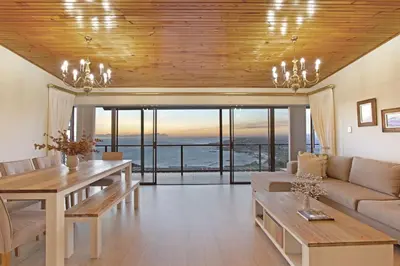 a living room with a couch and a table at Zaria Sun Penthouse in Cape Town