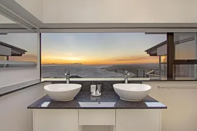 two sinks in a bathroom with a large window at Zaria Sun Penthouse in Cape Town