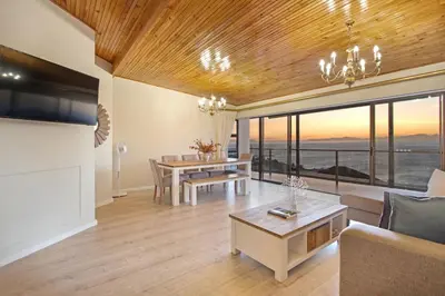 a living room with a couch and a table at Zaria Sun Penthouse in Cape Town
