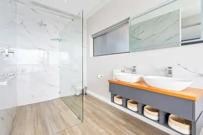 a bathroom with two sinks and a shower at Zaria Sun Family in Cape Town