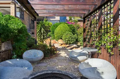 a patio with four stools and a table and chairs at Zaria Sun Family in Cape Town