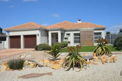 a house with palm trees in the front yard at Piece of Paradise in Hermanus