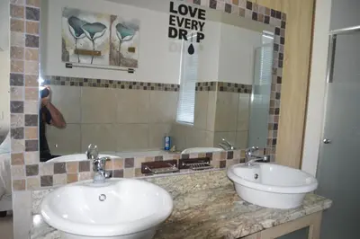 a bathroom with two sinks and a mirror at Piece of Paradise in Hermanus