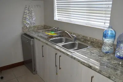 a kitchen counter with a sink and a window at Piece of Paradise in Hermanus