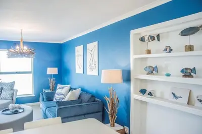 a living room with blue walls and a blue couch at Whale Rock 40 in Hermanus